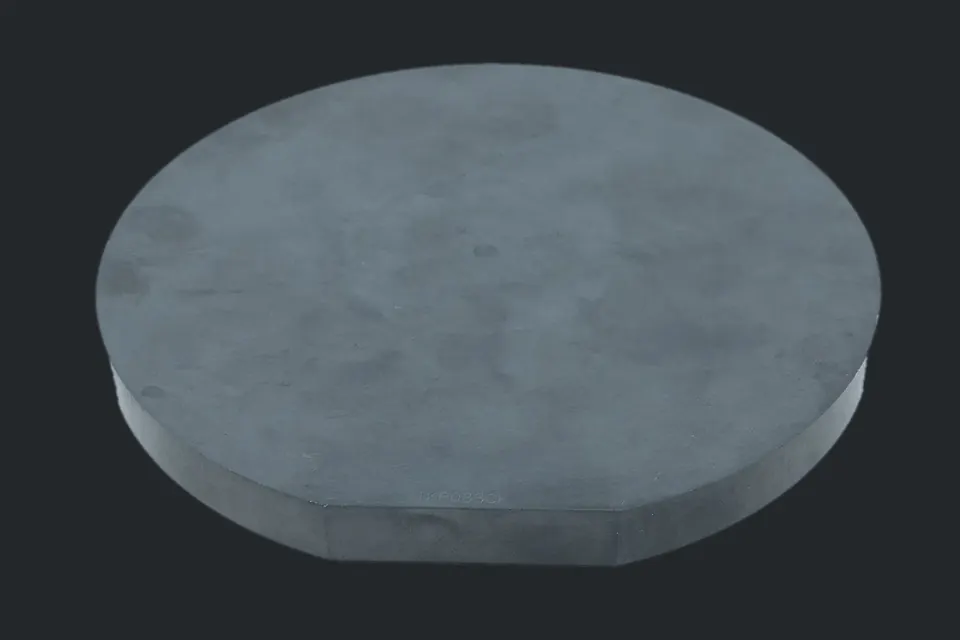A dark grey, round slab of silicon carbide on a graphite grey background