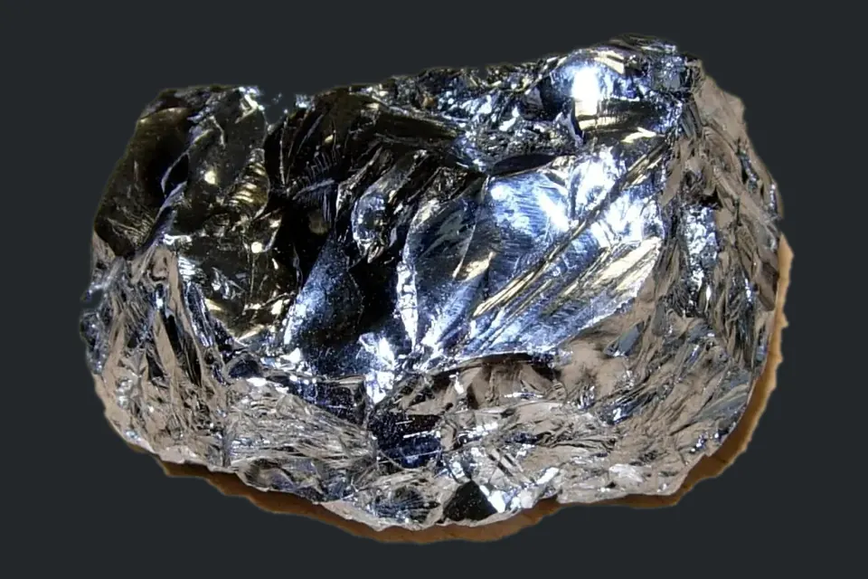 A shiny, silvery piece of purified silicon with conchoidal fracture surfaces